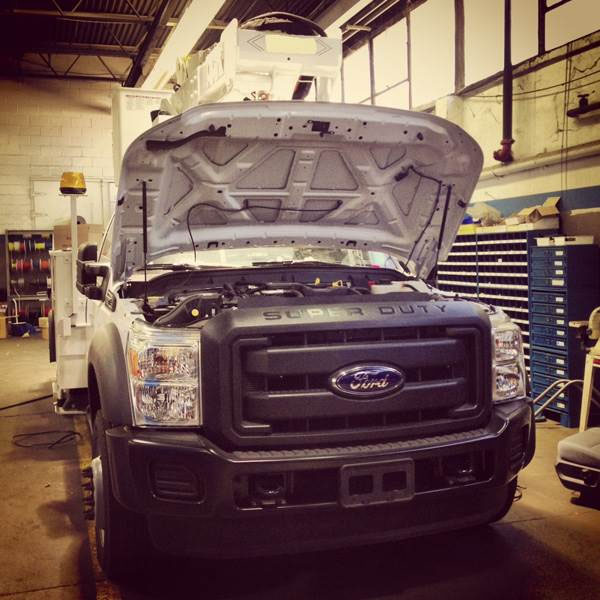 ford truck with hood open for service